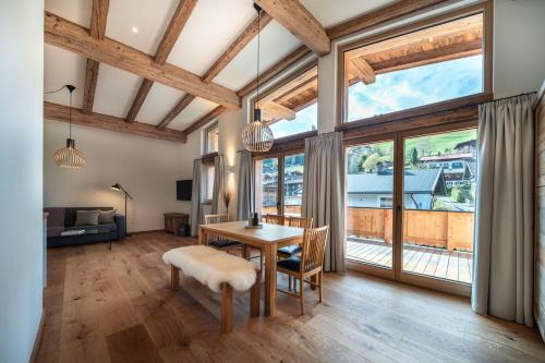 a dining room with a table and chairs and large windows at Wagstätt Residenzen Jochberg by Alpina-Holiday in Jochberg