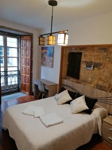 a bedroom with a large bed with two towels on it at Hostal Forest in Santiago de Compostela