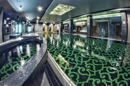 a swimming pool with a green floor in a building at Hotel Krasicki in Lidzbark Warmiński