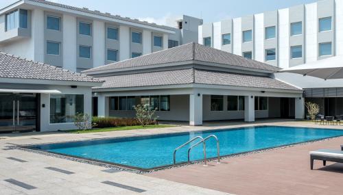 a swimming pool in front of a building at The Residency Towers, Rameswaram in Rāmeswaram