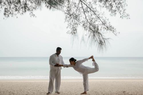 a man and woman standing on top of a beach at Banyan Tree Phuket - SHA Extra Plus in Bang Tao Beach