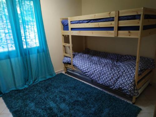 - une chambre avec des lits superposés et un tapis bleu dans l'établissement Babis apartment, à Kavala