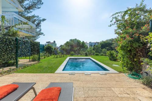 a swimming pool in the yard of a house at Estoril House in Estoril