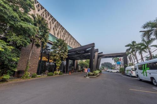 a street with a building with a parking lot at Holiday Inn Cikarang Jababeka by IHG in Cikarang