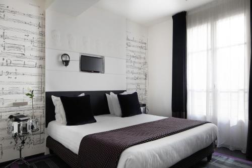 a bedroom with a large bed and a tv on the wall at Le 123 Sébastopol - Astotel in Paris