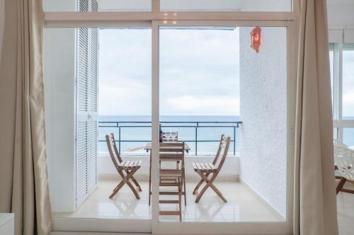 Skol Sea Views Apartments في مربلة: شرفة مع طاولة وكراسي وإطلالة على المحيط