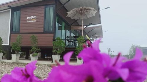 a house with pink flowers in front of it at บวกบัววิวรีสอทร์ in Nan