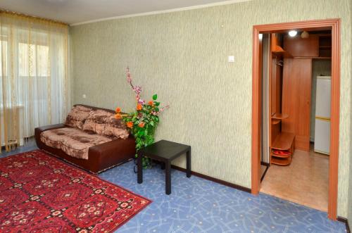 sala de estar con sofá y mesa en 1 комнатные апартаменты на Садуакасова 24, en Kokshetau