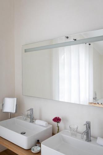 a bathroom with two sinks and a large mirror at Hôtel Les Hortensias du Lac in Hossegor