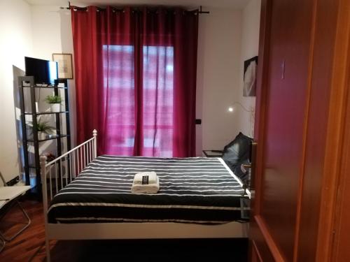 1 dormitorio con cuna y cortina roja en Leonardo Rome Holidays, en Fiumicino