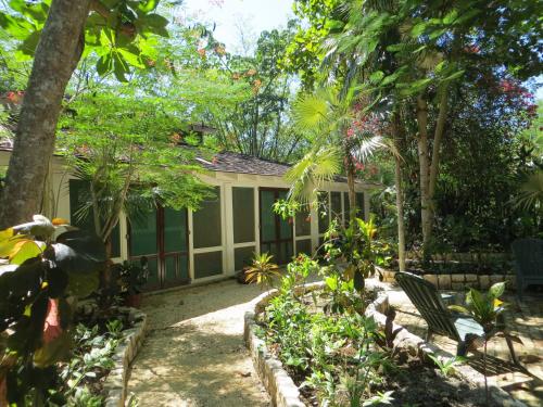 a garden in front of a house with trees at Tingalaya's Retreat in Negril