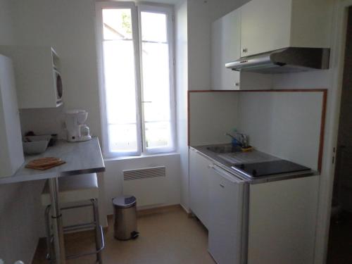 małą kuchnię ze zlewem i oknem w obiekcie Appartement d'Hôtes w mieście Guéret
