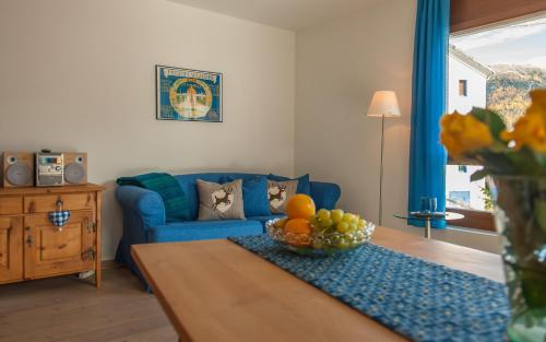 a living room with a blue couch and a table at Chesa Guardamunt in Celerina