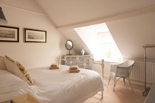 a bedroom with a white bed and a window at Lavender Cottage in Lyme Regis