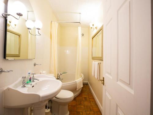 łazienka z umywalką, toaletą i wanną w obiekcie Wincham Hall Hotel w mieście Northwich