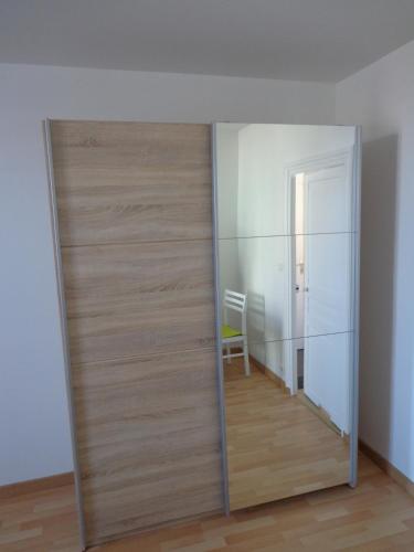 - une porte coulissante avec un miroir dans la chambre dans l'établissement Appartement d'Hôtes, à Guéret