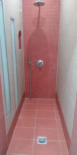 a bathroom with a red tiled shower with a mirror at Asterolithos in Fira