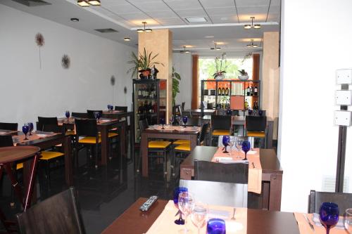un restaurante con mesas y sillas y copas de vino. en Hotel Ciutat d'Amposta, en Amposta