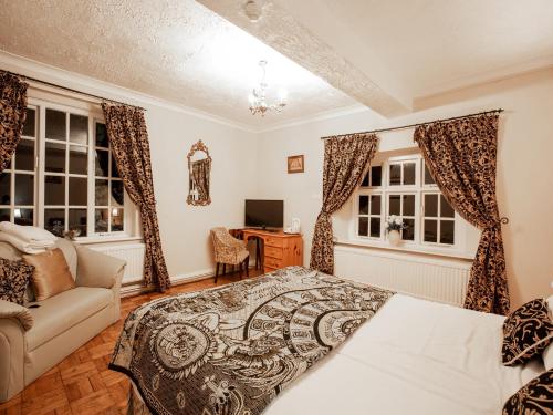 Schlafzimmer mit einem Bett, einem Schreibtisch und Fenstern in der Unterkunft Wincham Hall Hotel in Northwich