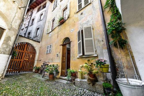 an old building with potted plants on the side of it at Al vicolo del Gallo APPARTAMENTO in Varallo