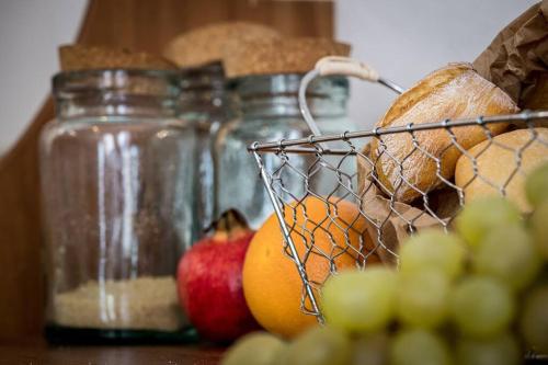 a table with jars of fruit and a basket of bread at Al vicolo del Gallo APPARTAMENTO in Varallo