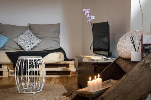 a living room with a couch and a table with candles at Al vicolo del Gallo APPARTAMENTO in Varallo