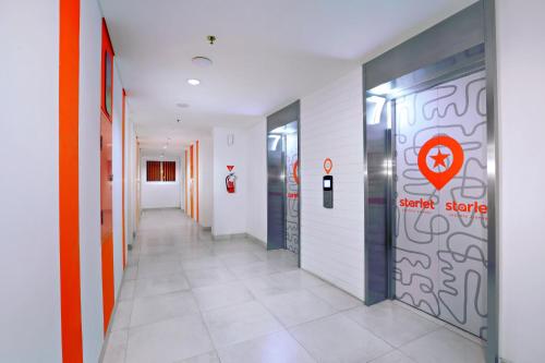 a hallway of an office building with a door with a sign on it at Starlet Hotel Jakarta Airport in Tangerang