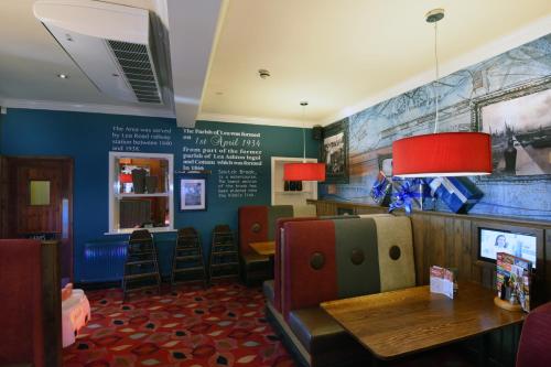 a restaurant with a waiting room with a table and chairs at Lea Gate by Greene King Inns in Preston