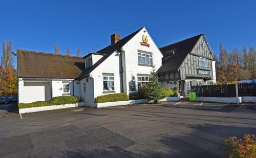 a white building with a parking lot in front of it at Lea Gate by Greene King Inns in Preston