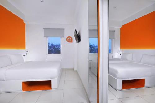 a small bedroom with two beds and a mirror at Starlet Hotel Jakarta Airport in Tangerang