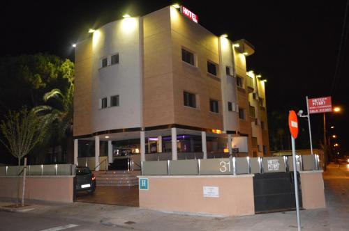 a building with a sign on top of it at night at Hotel 170 in Castelldefels