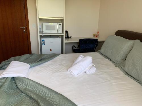 a bedroom with a bed with towels on it at Recanto da Sol in Florianópolis