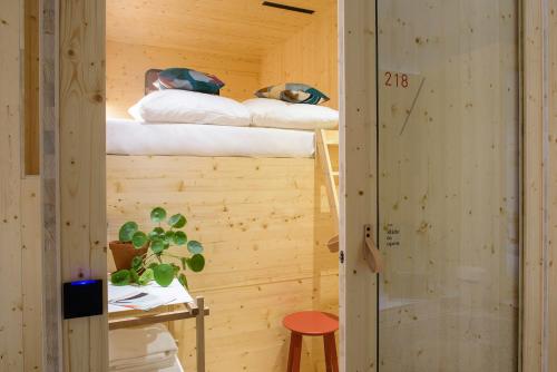 a room with two bunk beds and a stool at The Green Elephant Hostel & Spa in Maastricht
