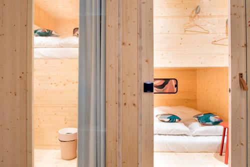 a room with two bunk beds in a wooden house at The Green Elephant Hostel & Spa in Maastricht