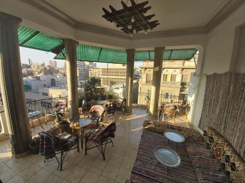 a balcony with tables and chairs and a view of a city at Cecilia Hostel in Cairo