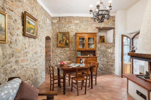 a living room with a wooden table and chairs at Casale del Bosco by VacaVilla in Casole dʼElsa