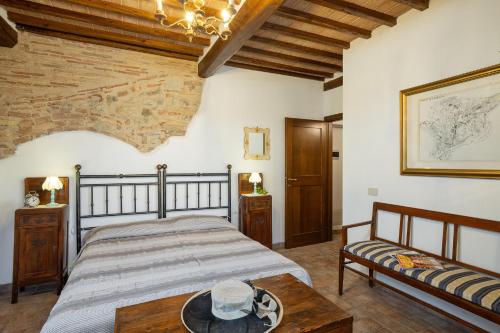 a bedroom with a bed and a table at Casale del Bosco by VacaVilla in Casole dʼElsa
