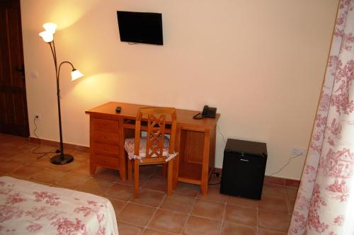a bedroom with a desk with a chair and a lamp at Hotel El Cortijo de Daimiel in Daimiel