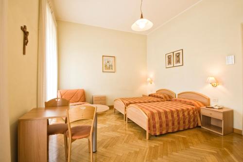 a bedroom with two beds and a table and a desk at Gästehaus Deutscher Orden in Rome