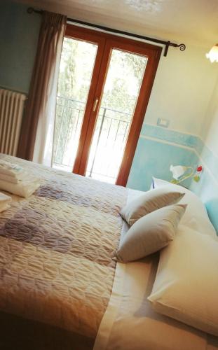 a bedroom with a large bed with a window at Hotel La Valle dell'Aquila in LʼAquila