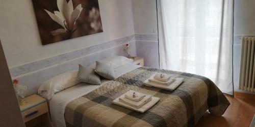 a bedroom with a bed with two towels on it at Hotel La Valle dell'Aquila in LʼAquila