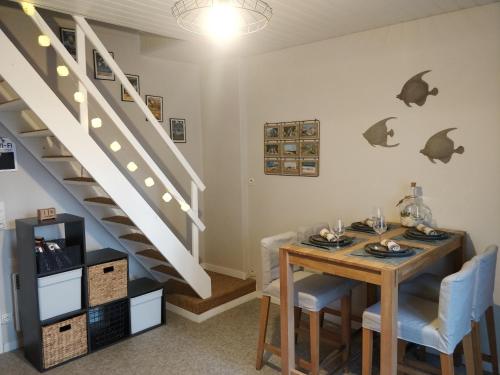 a dining room with a table and a staircase at LES JACINTHES in Berck-sur-Mer