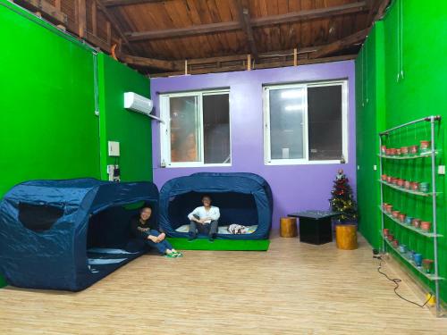 two children sitting in a play room with a green wall at 博愛泊旅讀心境 in Hualien City