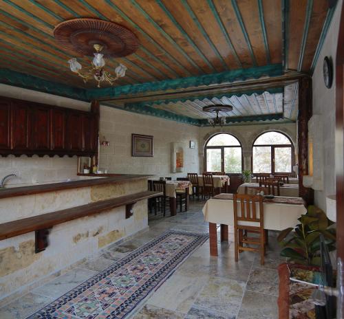 una cucina e una sala da pranzo con tavolo e sedie di Erenbey Cave Hotel a Göreme