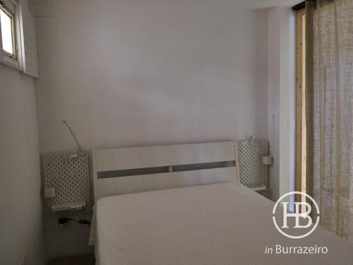
a bedroom with a white bed and a white wall at Herdade do Burrazeiro in Borba
