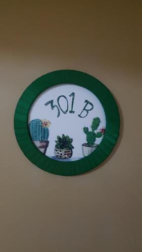 a clock on a wall with plants on it at Prive das Thermas - 301B in Caldas Novas