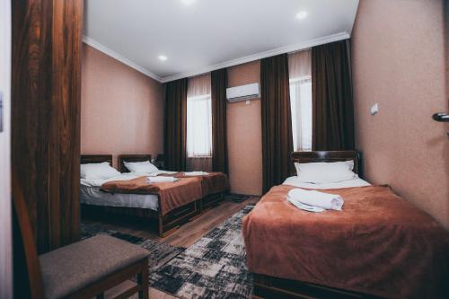 ein Hotelzimmer mit 2 Betten und einem Stuhl in der Unterkunft kutaisi Sunrise in Kutaissi