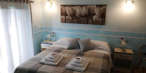 a bedroom with a bed with two towels on it at Hotel La Valle dell'Aquila in LʼAquila