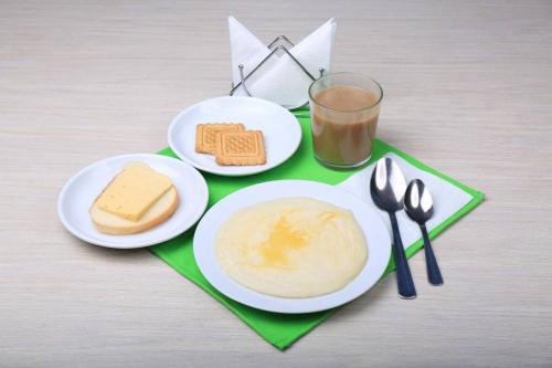 a table with two plates of food and a glass of milk at Mini-Hotel na Naberezhnoy in Kazan