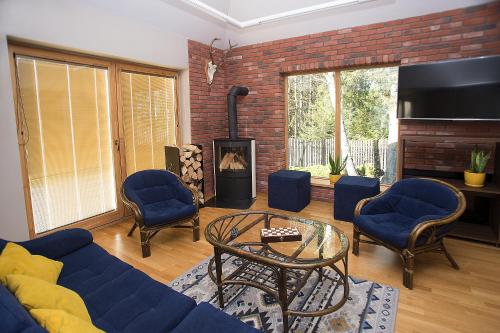 a living room with a blue couch and chairs and a fireplace at Pensjonat Orle in Krynica Zdrój